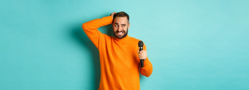 Mann unsicher mit Mikrofon