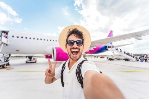 Mann auf Alleinreisen vor einem Flugzeug