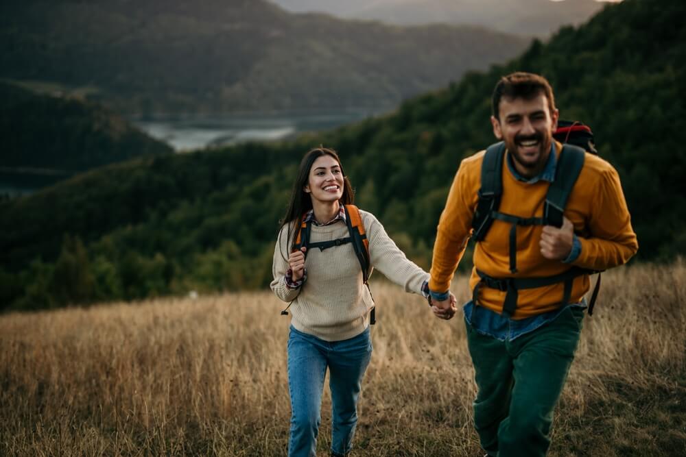 Paar hält Händchen beim Wandern